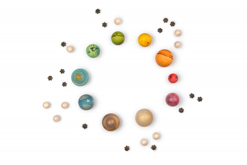 Composizione circolare del set Grapat Dear Universe con pianeti colorati, stelle e piccole sfere in legno.
