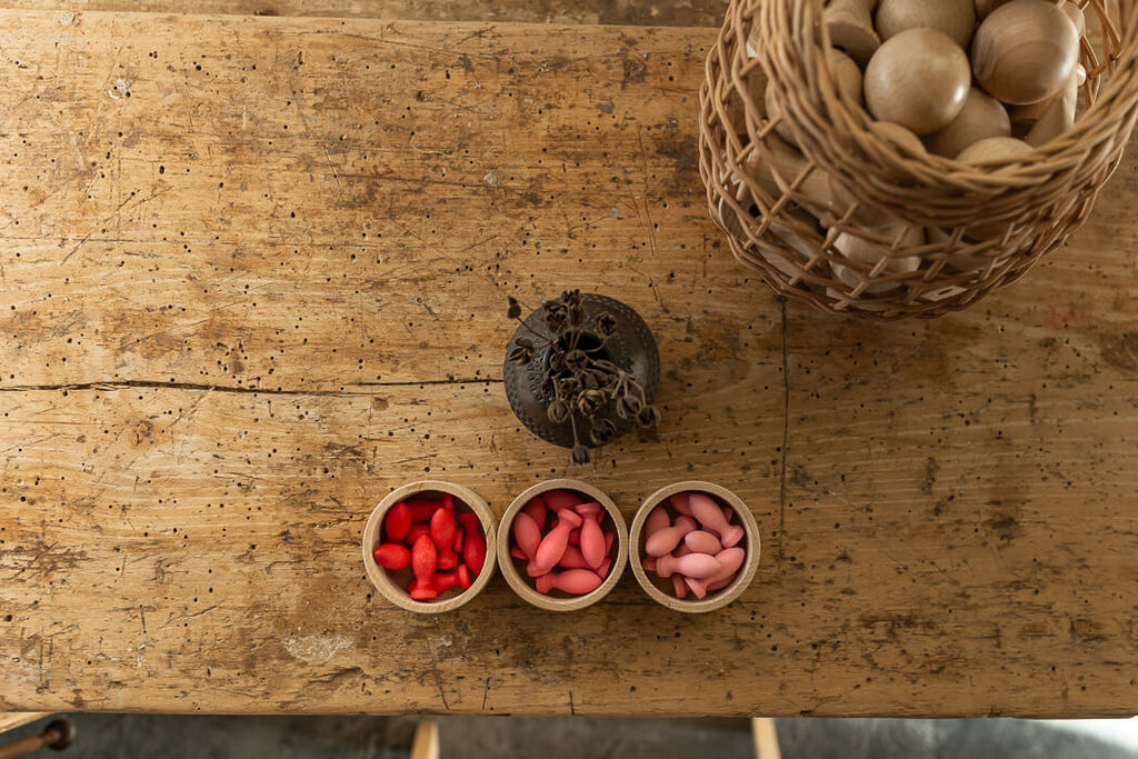 Petali rossi e rosa del set Grapat Mandala Flower Petals disposti in tre ciotole su un tavolo.