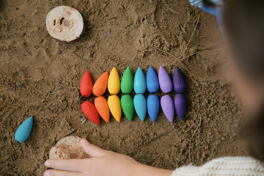 Composizione a mandala realizzata con i fiocchi di neve Grapat Mandala in legno colorato su fondo naturale