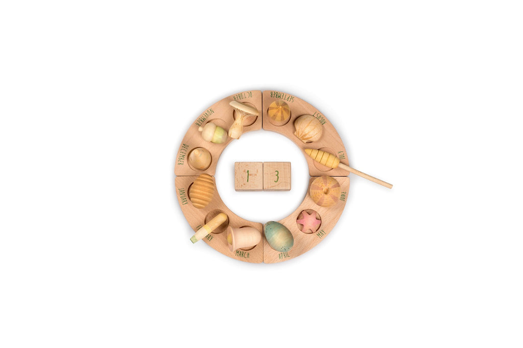 Set Grapat Wonders disposto a cerchio con elementi naturali in legno e mesi dell’anno incisi sulle basi