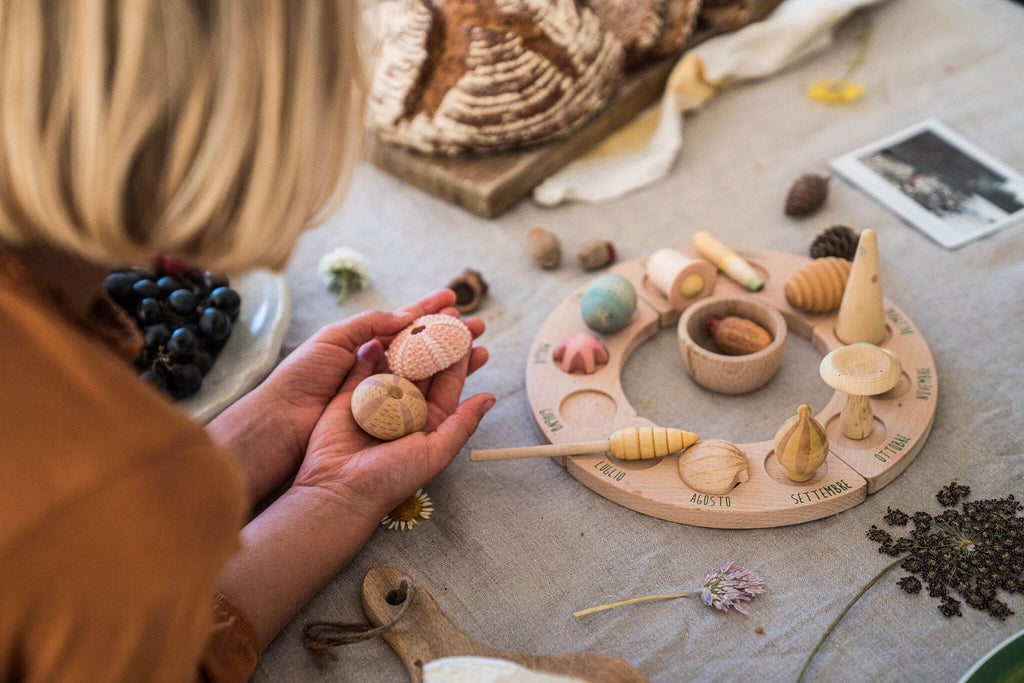 Bambina che tiene tra le mani due elementi scolpiti del set Grapat Wonders durante un momento di esplorazione sensoriale