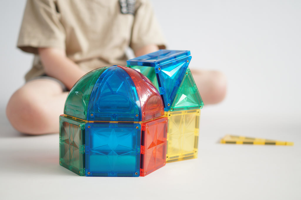 Bambino che costruisce con i magneti Cleverclixx Curved Pack Intense, gioco educativo STEM.